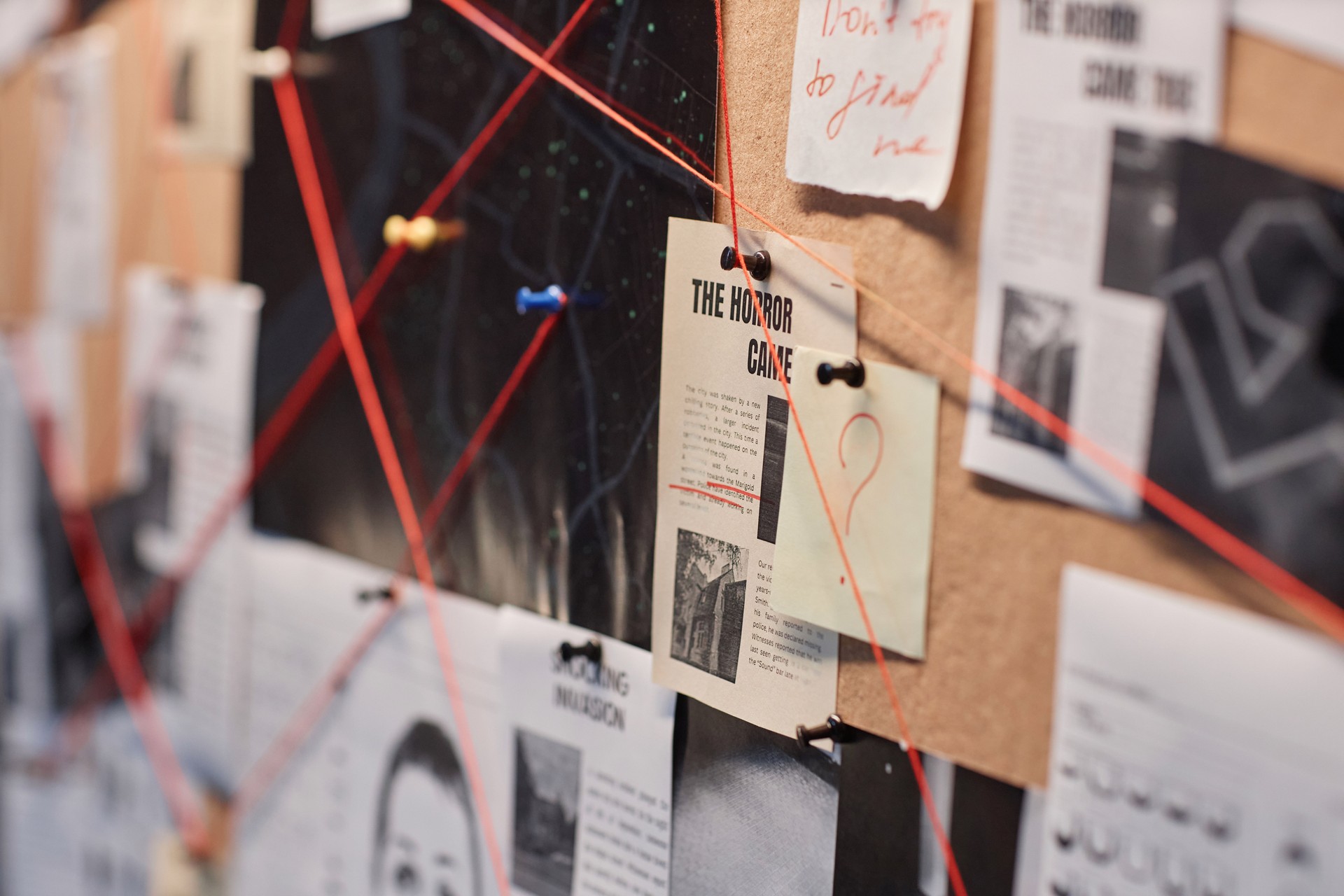 Closeup evidence board with red thread connecting pictures