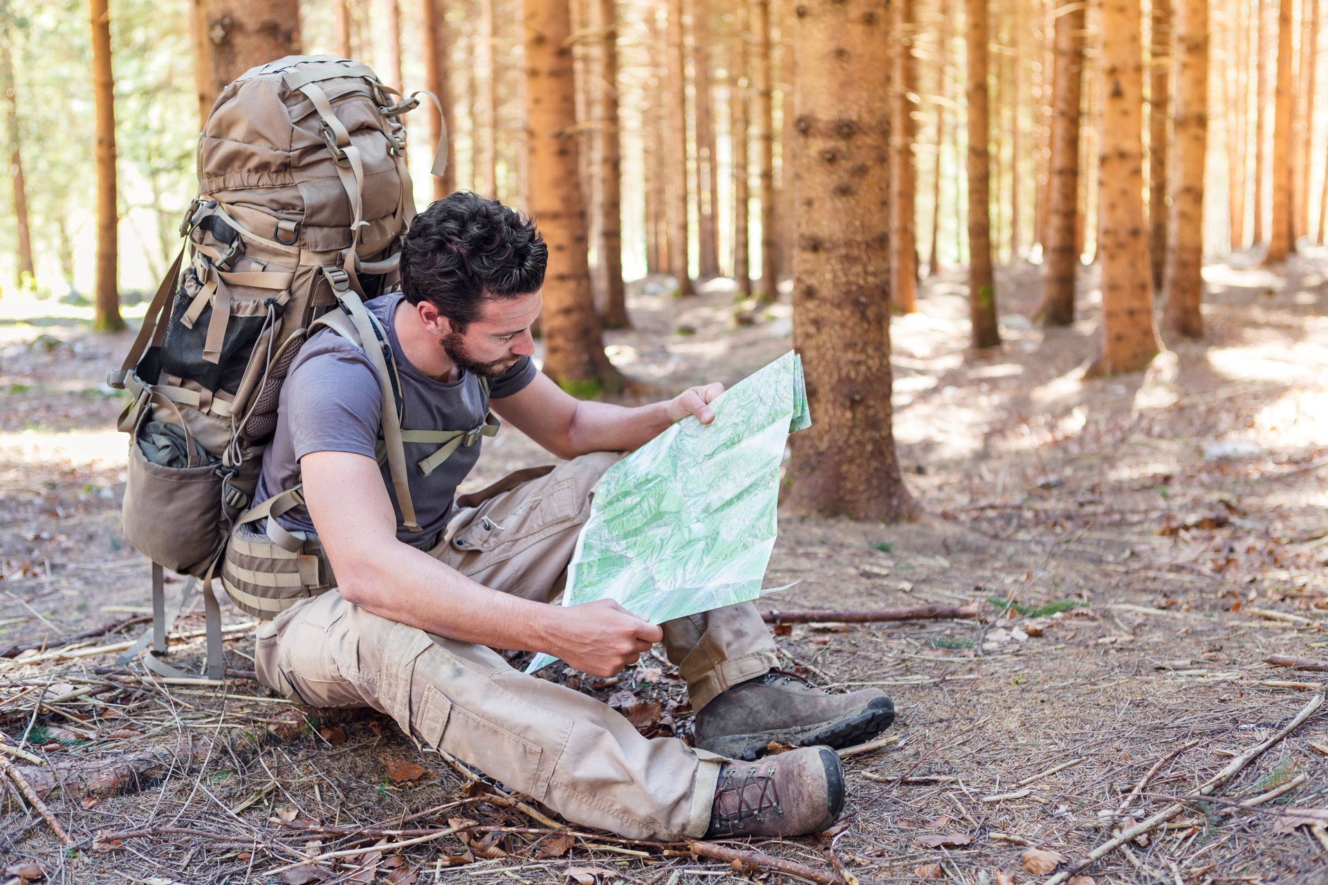 Man with Backpack and map searching directions